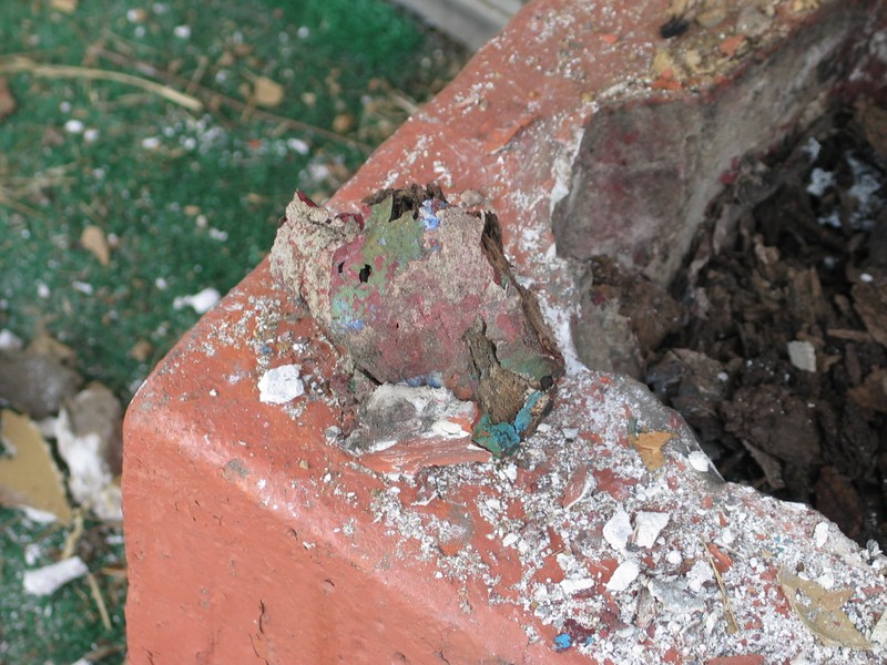 A piece of the rotted bottom of the pole- still painted brightly from before the Tikis became monochromatic.