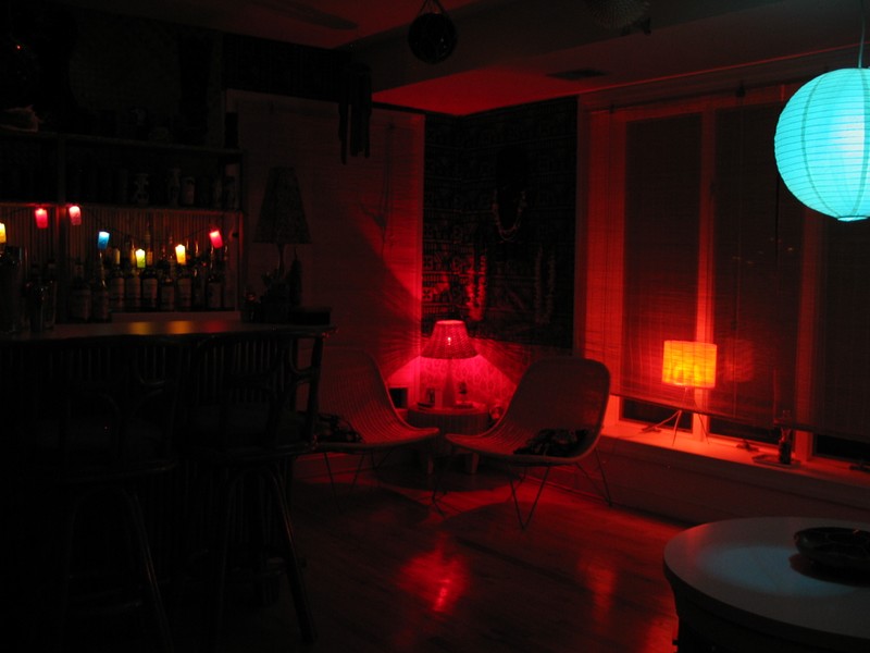 Standing in the front left corner of the Lounge looking across the room. The lamp on the bar is off, the space glows.