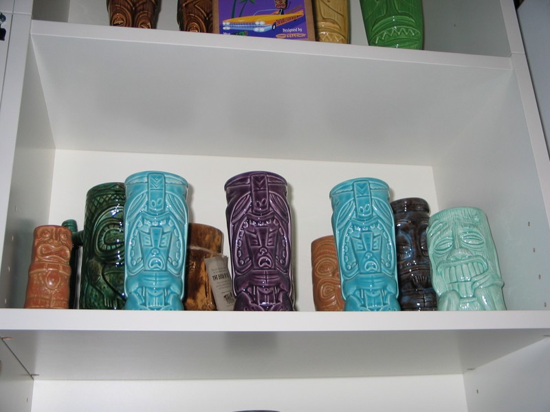 A shelf of special editions and event mugs.
