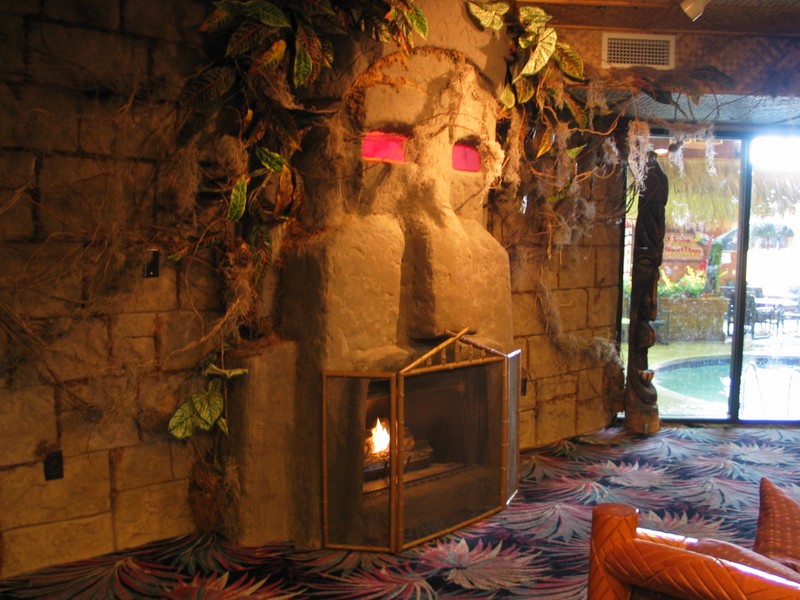 Inside the main lobby, the Tiki fireplace with another Tiki near the window. Through the window you can make out one of the many indoor pools. There are more small Tikis out there, but the camera would fog.