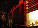 Behind us, along the Tapa wall, huge carved pannels and a bamboo shaded peek into the kitchens.