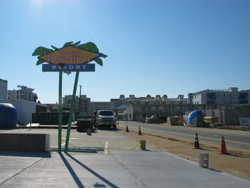 The Beach Colony's for sale sign is visible between the sign poles.