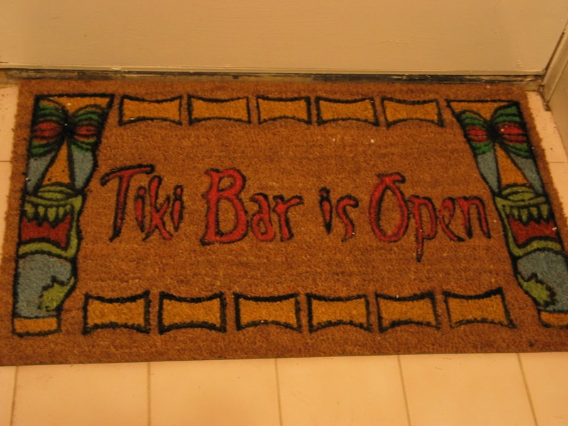 The nice new doormat my mom gave me for Yule! A very Tiki welcome! Indoors in winter and when the bar is closed, outside the bar door in nice weather when we're open.