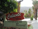 Just to his right is the sign for the resort and the masive entry frame.
