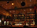 At the far left edge of the bar, the glass gives way to a lava rock wall and another dining room.
